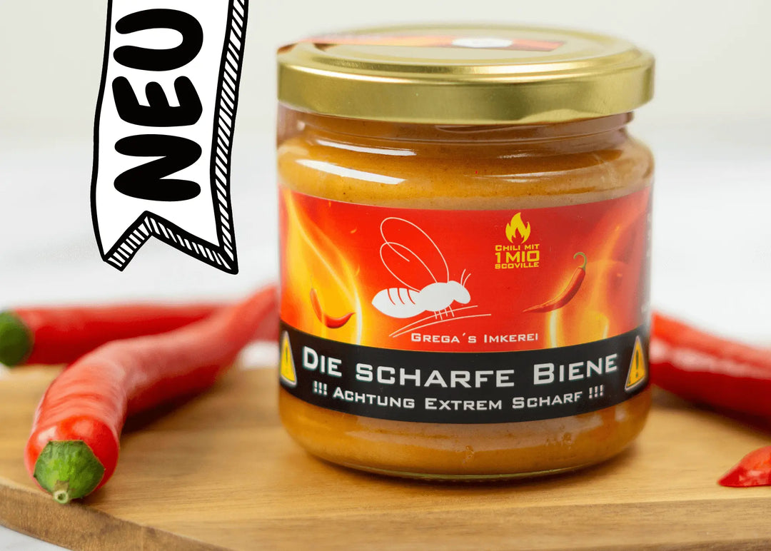"Glasgefäß mit 'Die Scharfe Biene' Honig verziert mit einem Bild der roten Carolina Reaper Chili."