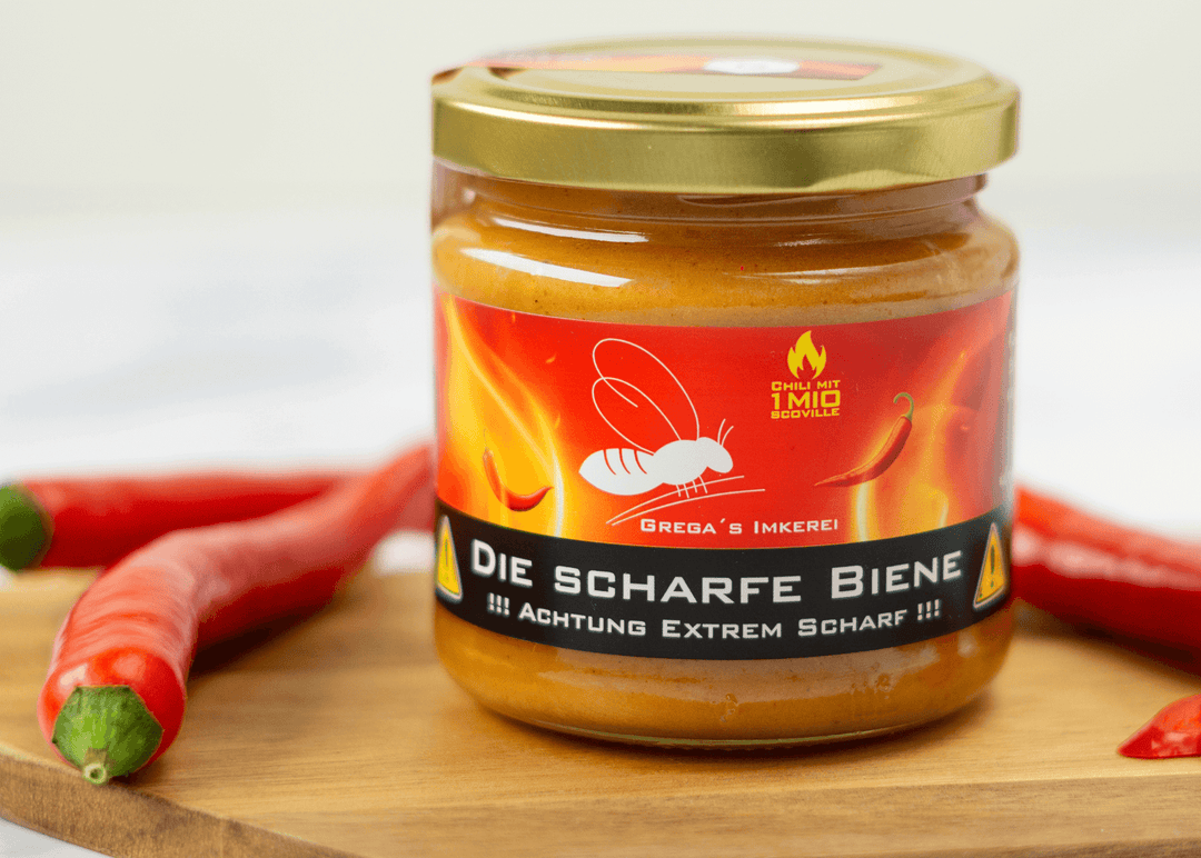 Hand hält einen Löffel voll 'Die Scharfe Biene' Honig über dem geöffneten Glas, bereit zum Würzen oder für Mutproben."